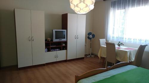 a bedroom with a bed and a tv and a cabinet at Apartment Cecilia Koprivnica in Koprivnica