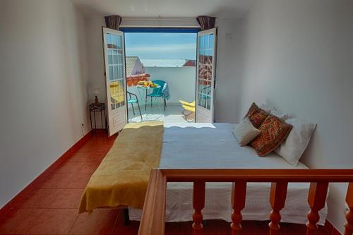 a bedroom with a bed and a view of the ocean at Like-home Boa Onda House-T4-Ericeira center in Ericeira