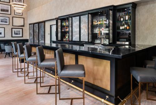 a bar with black stools and a row of liquor bottles at The Commonwealth in Richmond