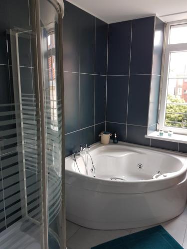 a bathroom with a white tub and a window at Ilot Désille in Boulogne-sur-Mer