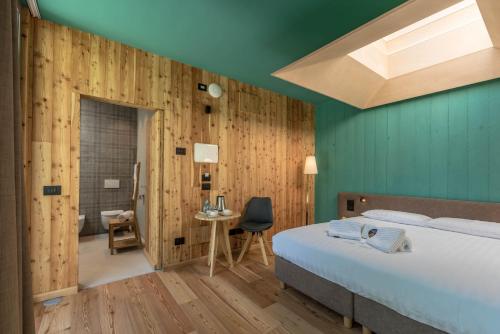 a bedroom with green walls and a bed and a table at Agritur La Dolce Mela - Adults Only in Vezzano