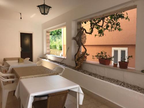 a restaurant with two tables and a window at Bolero Guest House in Lovište