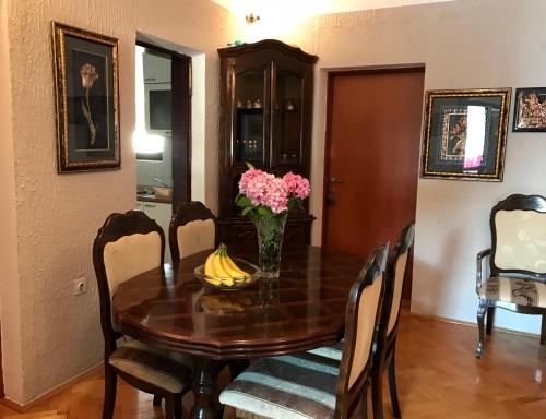 a dining room with a wooden table with bananas on it at Apartments Dijana in Kotor