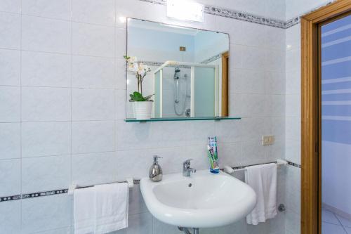 a white bathroom with a sink and a mirror at Residence Kimba in Rimini