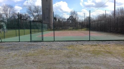 a tennis court with two nets on a tennis court at Chez Jo et Anne-Marie in Balleroy