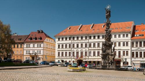 a group of buildings with a statue in the middle of a street at Hotel Prince de Ligne in Teplice