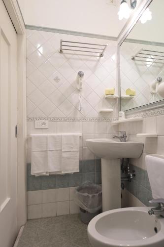 a white bathroom with a sink and a toilet at Hotel7Bello in Minori