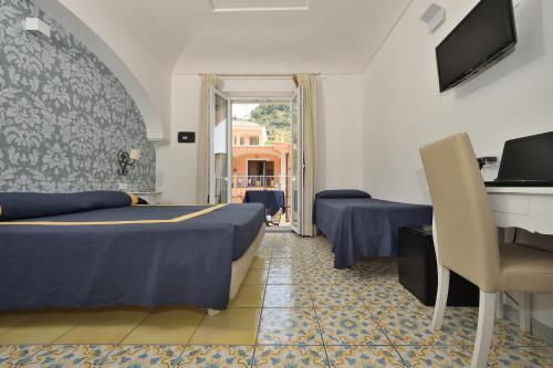 a hotel room with two beds and a desk at Hotel7Bello in Minori