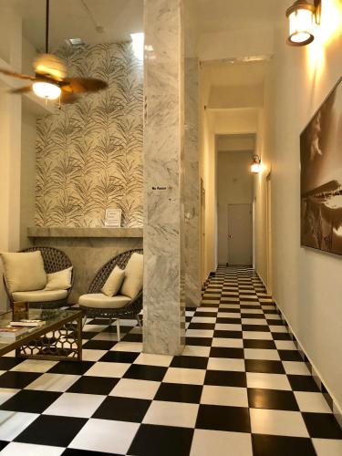 a hallway with two chairs and a checkered floor at Navona Studios in San Juan
