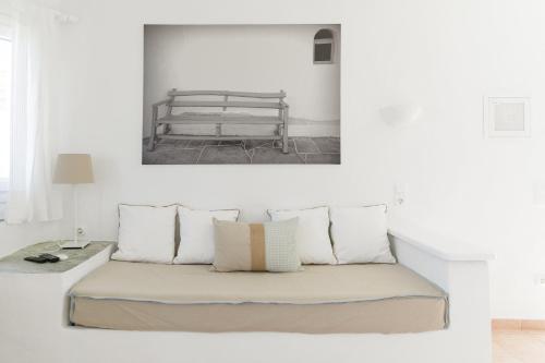 a bed with pillows and a bench in a room at Windmill Bella Vista in Artemonas