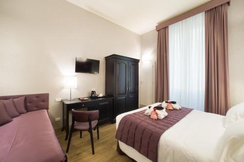 ein Hotelzimmer mit einem Bett mit zwei ausgestopften Tieren darauf in der Unterkunft Hotel Montreal in Florenz