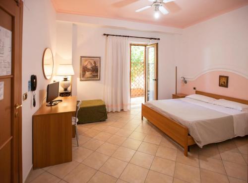 a bedroom with a bed and a desk with a computer at Oasi Relais in Vico Equense