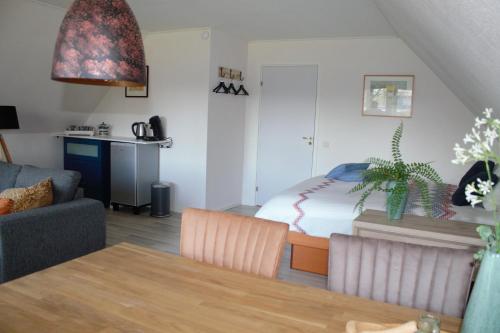ein Wohnzimmer mit einem Bett, einer Couch und einem Tisch in der Unterkunft B&B De Eikenhorst in Elsloo