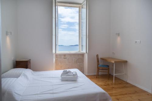 une chambre avec un lit, un bureau et une fenêtre dans l'établissement Beachfront 4-bedroom villa Sea Wave in Orebic, Croatia, à Orebić