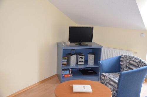ヘリングスドルフにあるVilla Inge Appartement 11のリビングルーム(テレビ、椅子、テーブル付)