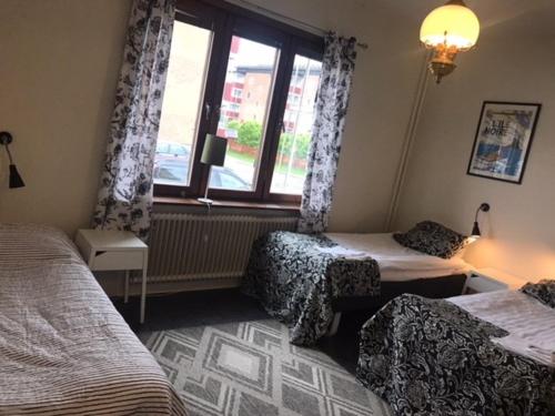 a hotel room with two beds and a window at Pensionat Augustin in Gällivare