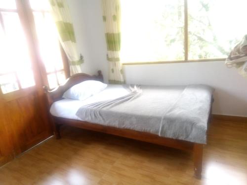 a small bed in a room with a window at Trinish homestay in Hatton