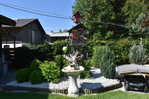 a bird bath in a garden with a bird house at Haus Laimbauer in Kirchdorf in Tirol