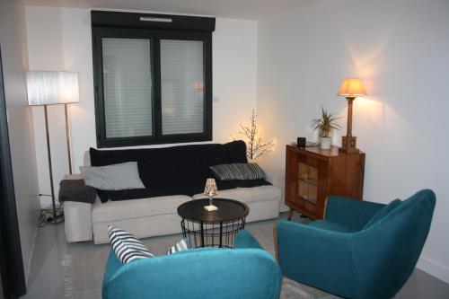 un salon avec deux chaises bleues et un canapé dans l'établissement Maison de Poul Briel, à Saint-Guénolé