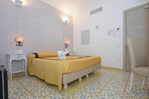 a bedroom with a bed with a yellow bedspread at Hotel7Bello in Minori