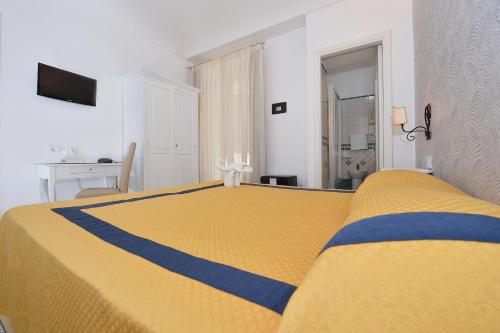 a yellow and blue bed in a white room at Hotel7Bello in Minori