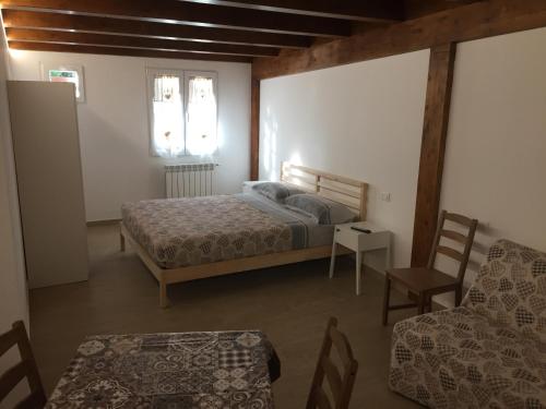 1 dormitorio con 1 cama, 1 silla y 1 mesa en I Villini en Pescara