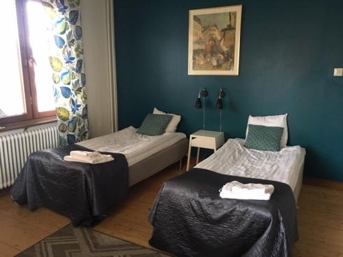 Cette chambre comprend 2 lits jumeaux et un mur bleu. dans l'établissement Pensionat Augustin, à Gällivare