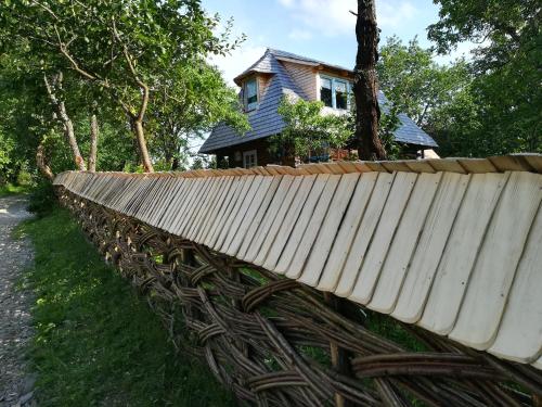 a wooden fence in front of a house at Complex Tradițional Casa din Vale Breb in Breb