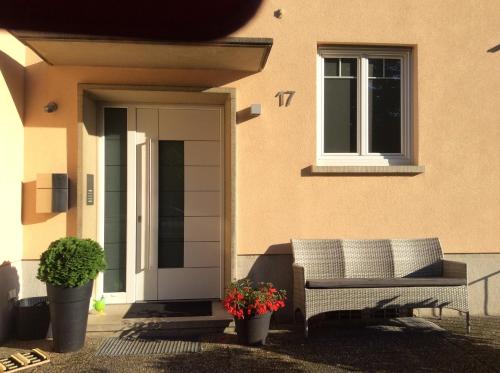 a bench sitting outside of a house with two plants at Heidelberg Appartements Berger in Heidelberg