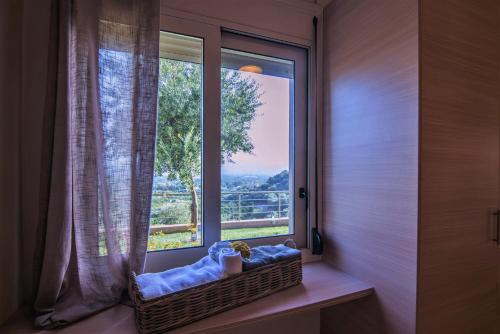 a basket sitting in front of a window with a view at Aksos Suites Accessible Accommodation in Ayiá
