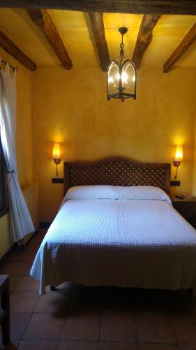 a bedroom with a bed and a chandelier at Posada Calera in Valle De Villaverde
