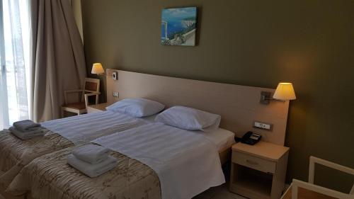 a bedroom with a bed with white sheets and pillows at Ostria Hotel Kakovatos Beach in Zakharo