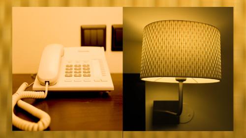 a phone and a lamp on a table at Remas Hotel Suites - Al Khoudh, Seeb, Muscat in Seeb