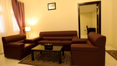 a living room with a couch and a coffee table at Remas Hotel Suites - Al Khoudh, Seeb, Muscat in Seeb