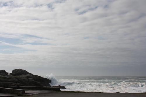 una ola chocando en una playa con el océano en Maison de Poul Briel, en Saint-Guénolé