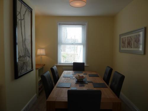 a dining room with a wooden table and chairs at Cornerstone in Portland