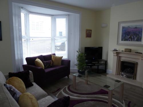 a living room with a purple couch and a fireplace at Cornerstone in Portland