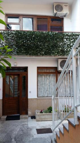 a white house with a wooden door and stairs at Apartment House Aria in Baška Voda