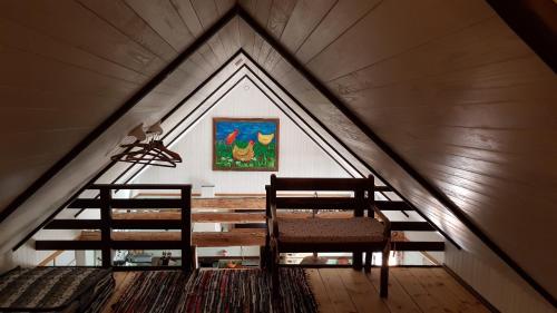 um quarto no sótão com duas cadeiras e um quadro na parede em Männi Summerhouse em Kassari