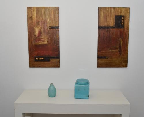 three wooden doors on a white wall with a table at De la Plaza Hotel in Maldonado