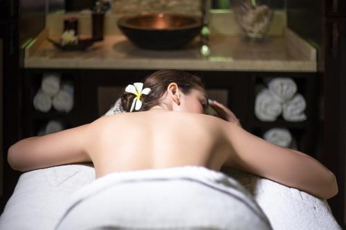 a woman laying on a bed in a room at Coral Reef Club in Saint James