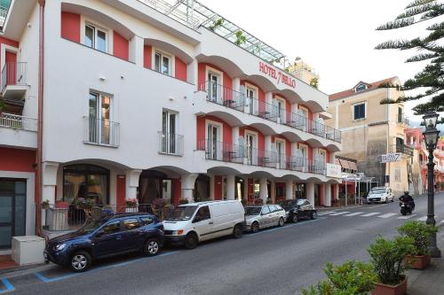 una calle con coches estacionados frente a un edificio en Hotel7Bello, en Minori