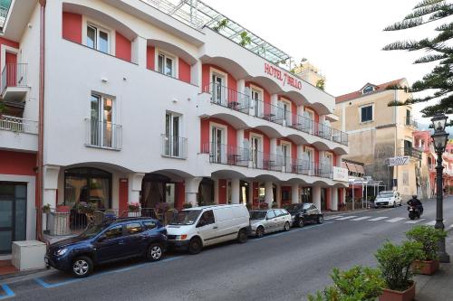uma rua com carros estacionados em frente a um edifício em Hotel7Bello em Minori