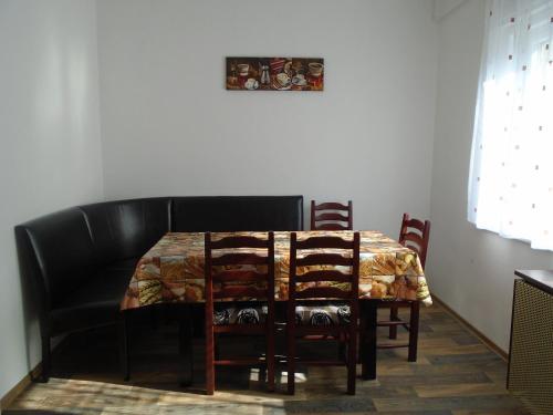 a dining room table with chairs and a couch at Privát Szállás Miskolctapolca in Miskolctapolca