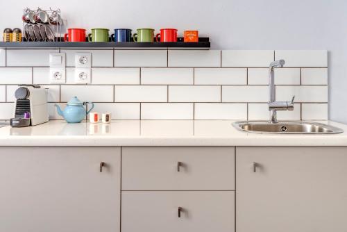 a kitchen with white cabinets and a sink at Homey in Ermoupoli