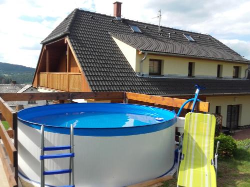 a house with a large swimming pool in front of a house at Apartmány Lucie in Zdíkov