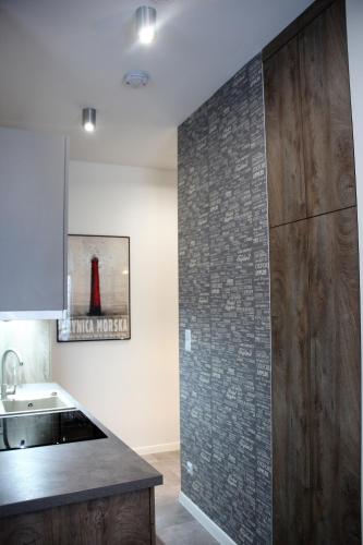 a kitchen with a tile wall and a sink at Apartamenty4you - Apartamenty Atlantic in Sopot