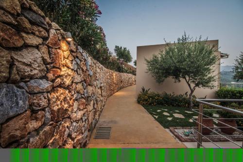 a stone wall next to a walkway at Aksos Suites Accessible Accommodation in Ayiá
