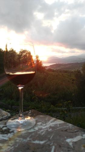 a glass of wine sitting on a table with the sunset at Casa vacanze Alfano in Ascea