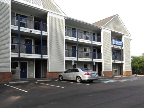 a car parked in a parking lot in front of a building at Studio 6 Greensboro NC I40 in Greensboro